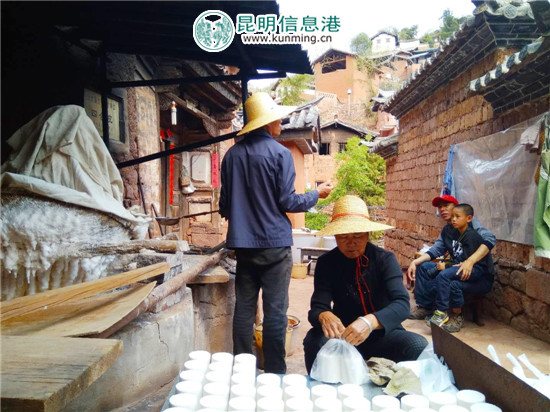 杨斌全（戴草帽站立者）与老伴正在制作诺邓井盐。记者江枫/摄